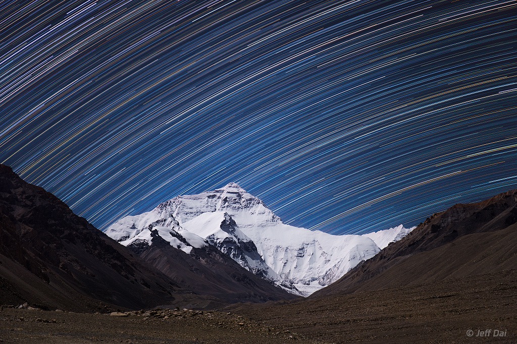 چشم‌انداز بلندترین کوه زمین با ردی از ستارگان در پس‌زمینه