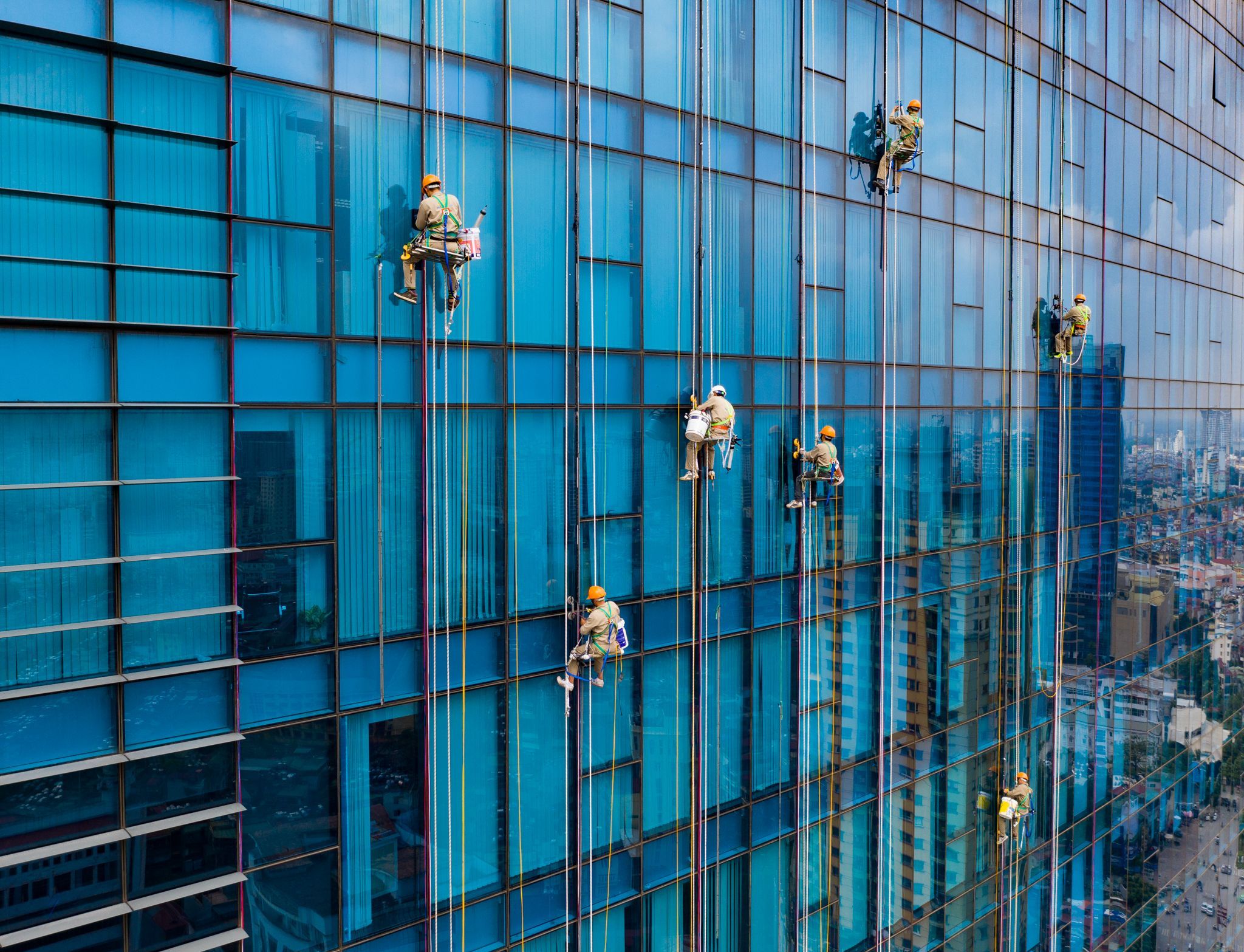 کارگرانی که در ارتفاع 120 متری از سطح زمین برای نصب نمایشگر LED کار می‌کنند. عکاس: TRAN TUAN VIET